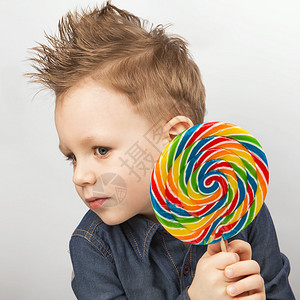 男孩吃棒糖快乐的小孩带着大糖果在白色图片