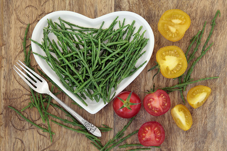一种心形瓷盘上的含硫磺和番茄蔬菜的饮食健康食品图片