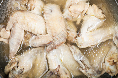 炖锅里的油腻鸡汤里有很多煮鸡翅背景图片