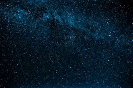 蓝色夜空背景下的银河和流星图片