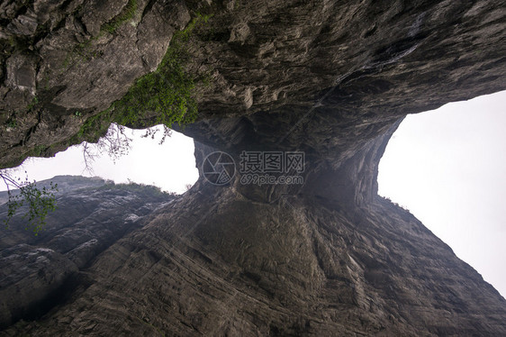 一座大水侵蚀了两座山峰之间的洞穴在Chiangjiajie的锡亚门山图片