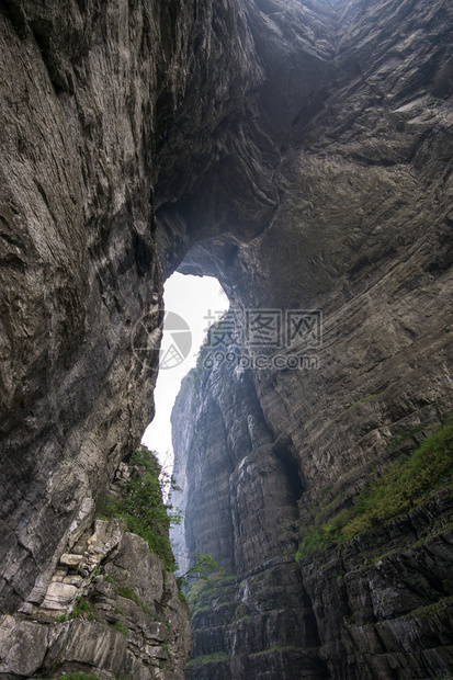 一座大水侵蚀了两座山峰之间的洞穴在Chiangjiajie的锡亚门山图片