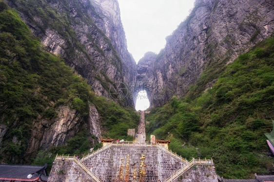 一座大水侵蚀了两座山峰之间的洞穴在Chiangjiajie的锡亚门山图片