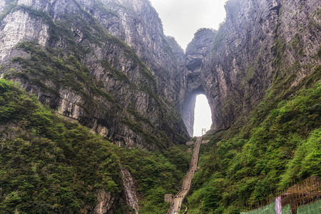 一座大水侵蚀了两座山峰之间的洞穴在Chiangjiajie的锡亚门山图片