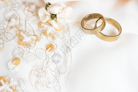 放在婚纱上的两个结婚戒指图片