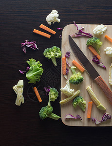 混合蔬菜有胡萝卜西兰花椰菜紫甘蓝生菜在切板上用刀图片