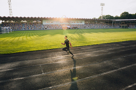 赛跑者在体育场的跑道上图片