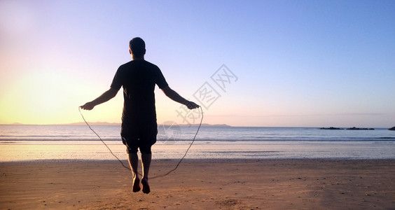 日落时在海滩跳绳跃4图片