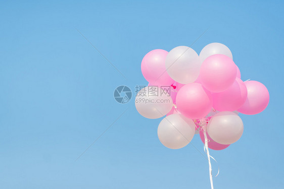 蓝色天空上的粉色和白色气球图片