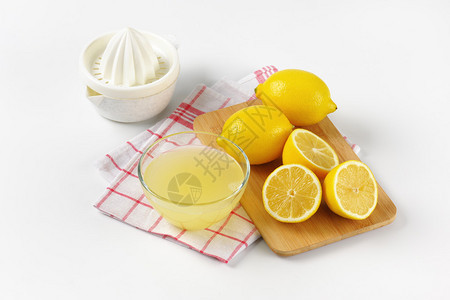 鲜柠檬汁柠檬挤压器和成熟的柠檬背景图片
