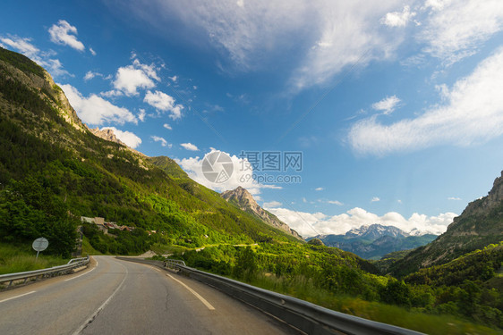 在风景秀丽的高山景观和喜怒无常的天空中铺设了两条横穿山脉和森林的车道从车载摄像头的全景视图意大利法国阿尔卑斯山的夏季冒图片
