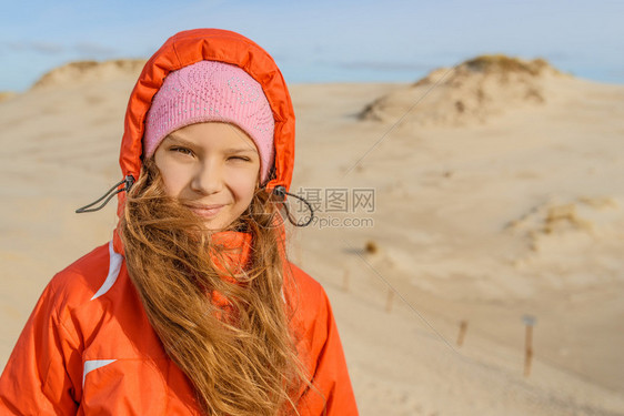 穿着红裙子的小女孩在Leba白沙丘上站在沙漠边上波兰美拉尼图片