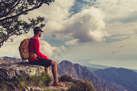 徒步旅行者登山者或越野跑者看着鼓舞人心的山脉景观在夏季自然户外健身和健康的生活方式有成就的登图片