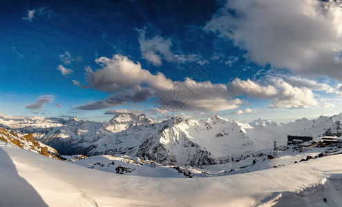 高山峰顶在日落时的全景雪山上的风景图片