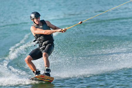 极限运动Wakeboarder享受在湖上骑行和切割水面的乐趣背景