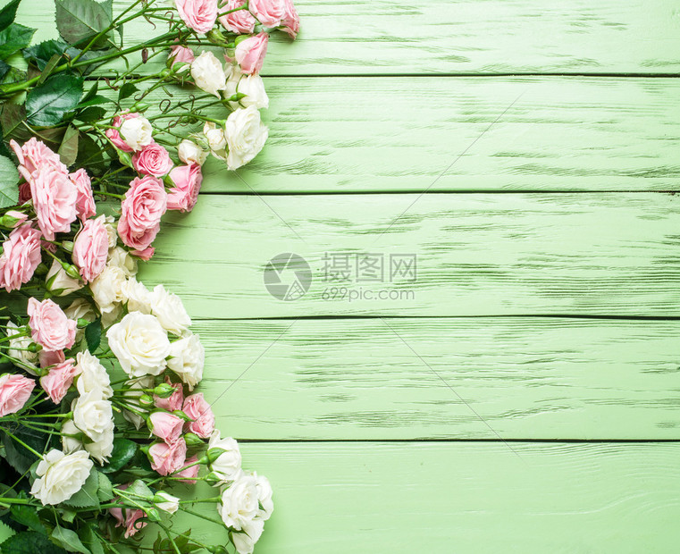 绿色木制背景上的精致新鲜玫瑰图片