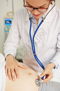 医生用听诊器检查孕妇背景图片