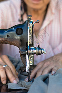 古老的缝纫机在老人设计师上图片