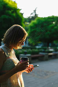 夏日喝咖啡看手机的女人背景图片