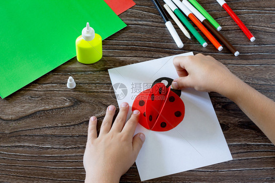 孩子将纸张细节粘在明信片上孩子用瓢虫做明信片木桌上的胶水纸剪刀儿童艺术项目图片
