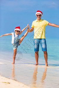 在奇异海滩的圣塔帽子圣诞礼堂的小女图片