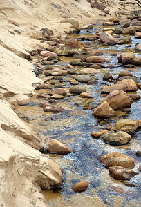 沙质淡水小溪中的砂岩巨石图片