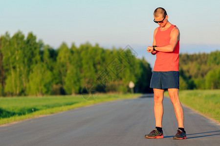 男子赛跑者在夏日落时分在乡间小路上奔跑图片
