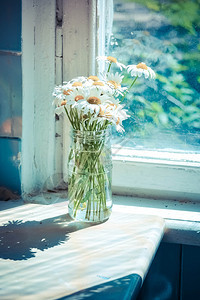 玻璃库里的花束在靠近窗口的桌背景图片