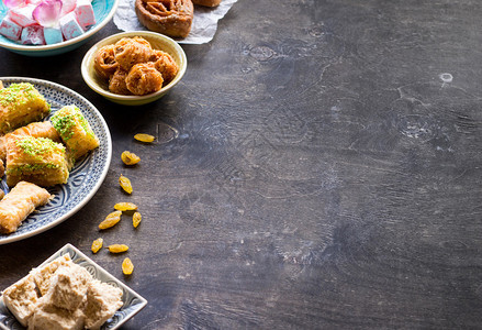 背景和各种传统的东方甜点木桌上的不同阿拉伯糖果仁蜜饼图片