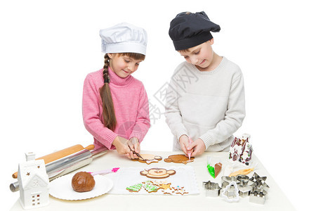 穿着厨师帽做圣诞饼干的漂亮男女孩图片