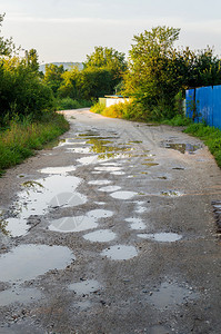 雨后的坏地面道路上的水坑带有脏水坑的洞或坑洞图像作为道路维护的运输标志和汽车悬架对汽图片