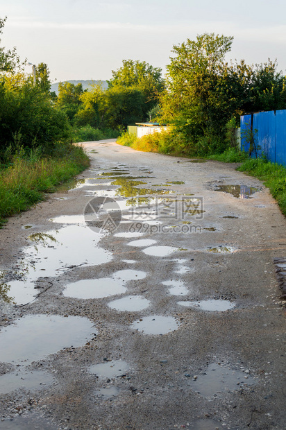 雨后的坏地面道路上的水坑带有脏水坑的洞或坑洞图像作为道路维护的运输标志和汽车悬架对汽图片