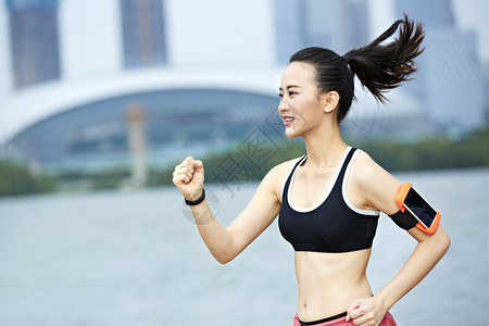 年轻美丽的亚洲女跑步者在城市公背景图片
