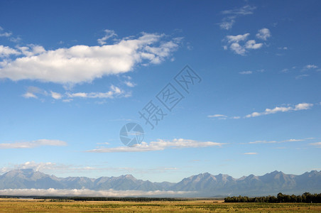 东萨彦岭和MunKuSardyk山上空的蓝天和积云照片部分着色图片