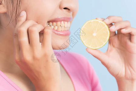 亚洲年轻女子牙齿过敏的亚洲女青年吃柠图片