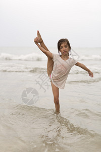 海滩上做水上体操的小女孩图片