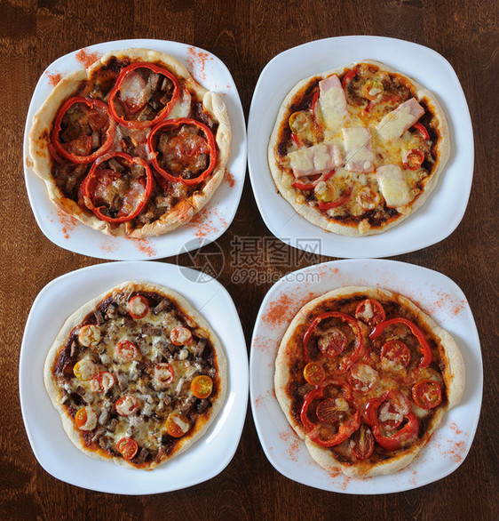四圆披萨在白色盘子上的四圆披萨在一图片