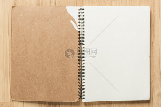 在木背景上打开笔记本用于设计的空白页面背景与文图片
