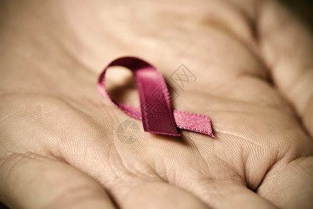 粉色丝带的缝合以在男人的手掌中提高对乳腺癌的认识并产图片