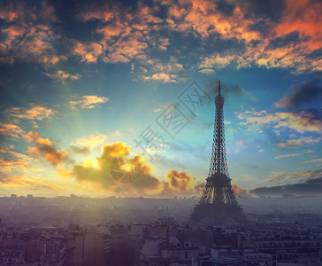 美丽的日落和戏剧天空在法国巴黎上空与埃菲尔铁塔在秋季的晚上复古图片
