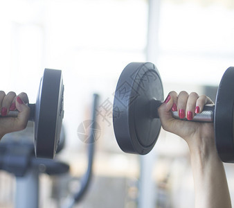 女健身房在健身工作室健身房锻炼哑铃自由重量图片