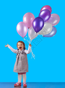 带着蓝底气球的快乐小女孩图片
