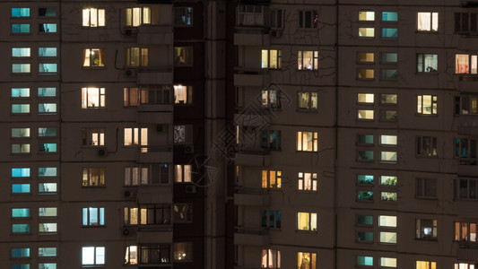 夜里多层板式公寓楼的窗户灯图片