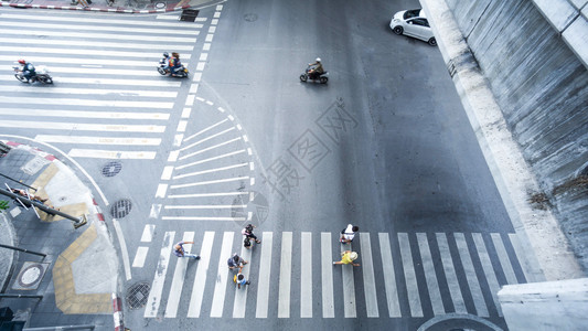 白天在城市道路上行驶的人和汽车图片