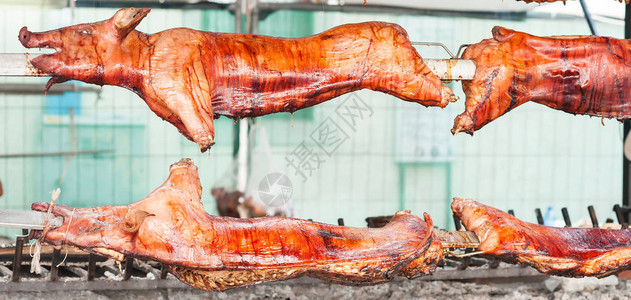 在烤肉架上烤的猪肉胴体图片