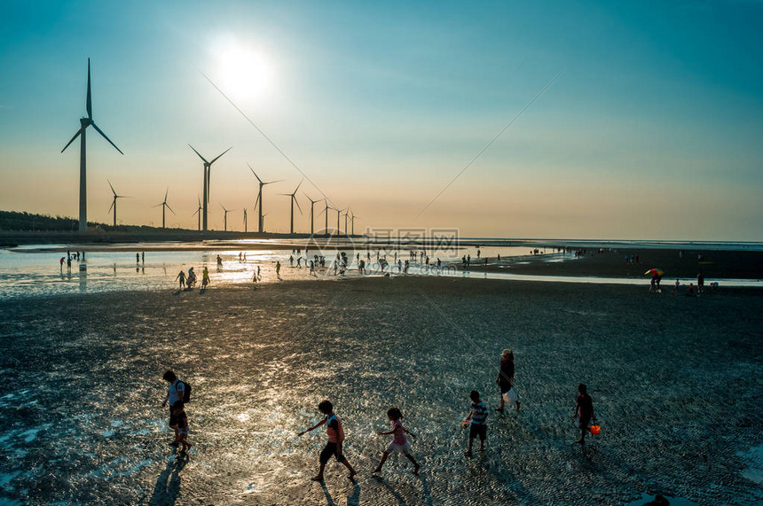 海滨湿地风力发电机组剪影图片