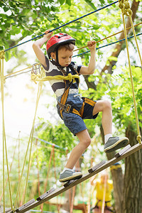 孩子们在冒险公园攀爬男孩喜欢在绳索课程冒险中攀爬攀爬高铁公园的孩子快乐的男孩在冒险公园玩耍图片