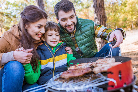 秋天公园烤肉烧烤场上幸福家庭烤图片