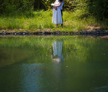新娘和新郎在池塘图片