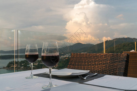 两杯红葡萄酒在日落背景图片